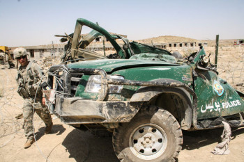 Soldado de los EEUU inspeccionando un vehículo de la policía Afgana destrozado durante un ataque de los Talibán. Foto: Amador Guallar