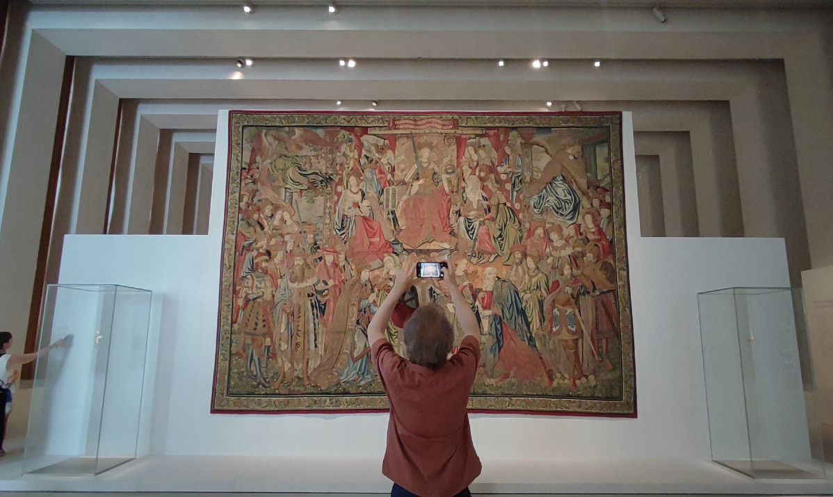 Visitante sacando foto de un tapiz en la Galería de las Colecciones Reales