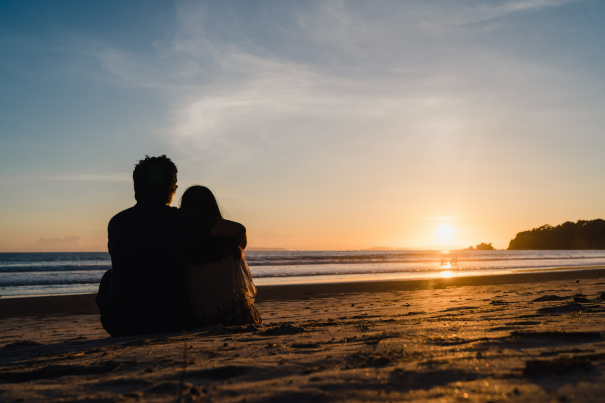 Young asian couple watching sunset near beach sweet couple happy relax enjoy love and romantic moment