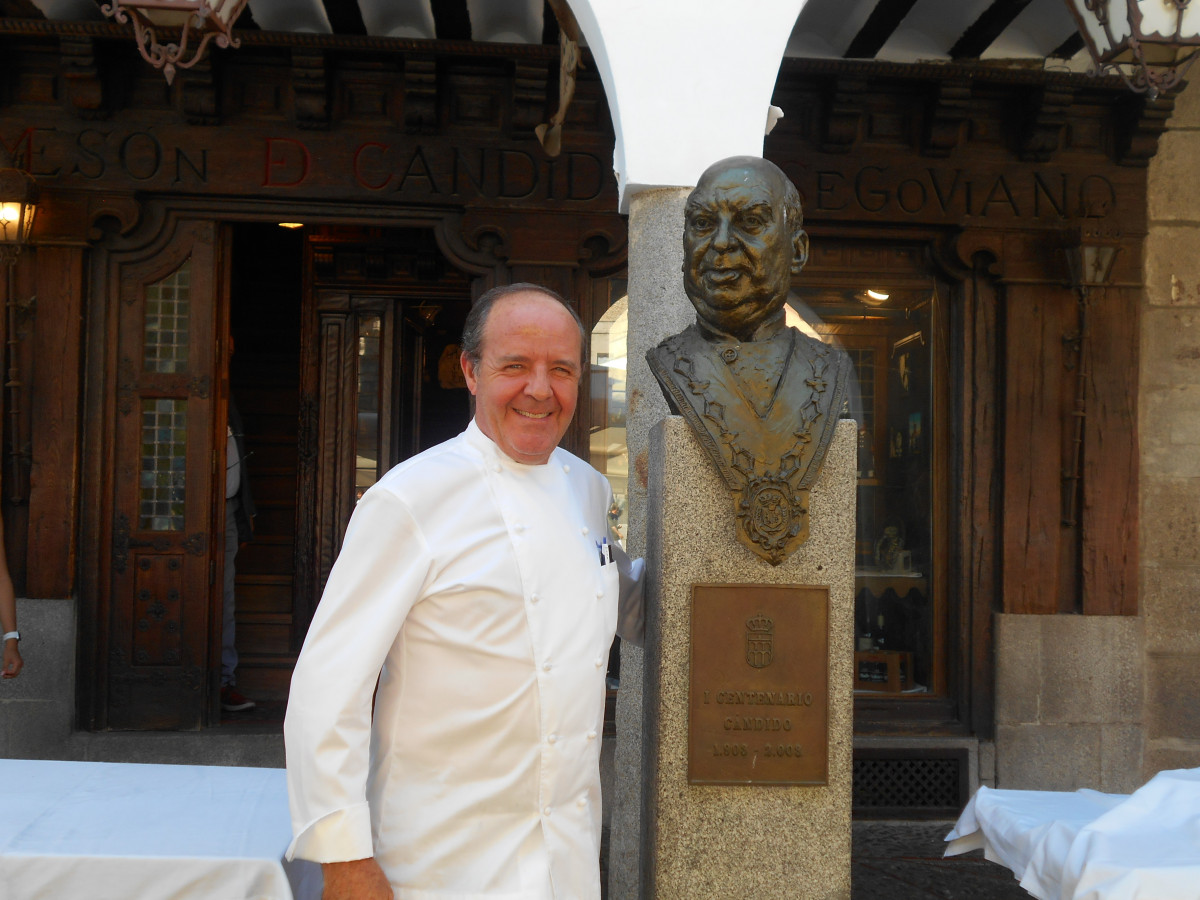 Cándido, regente del Mesón, posa junto la efigie de su abuelo